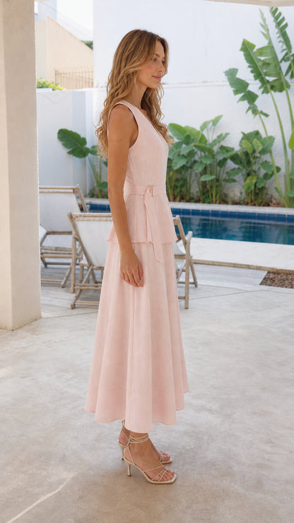 Woman wearing pink V-neck peplum midi dress from the side