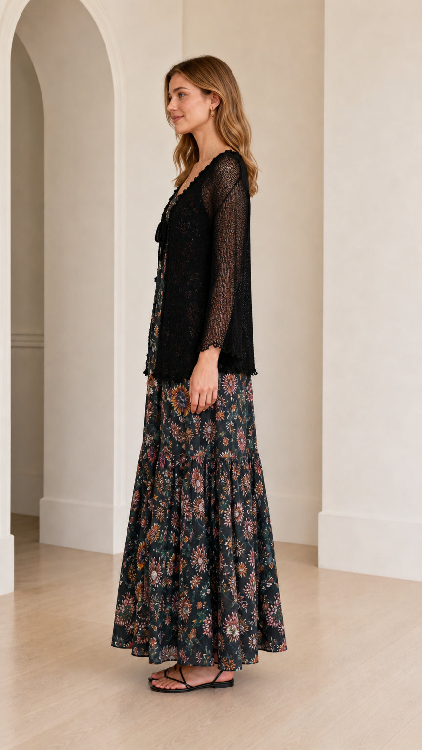 Side view showing the flowing floral maxi dress and lightweight black cardigan overlay