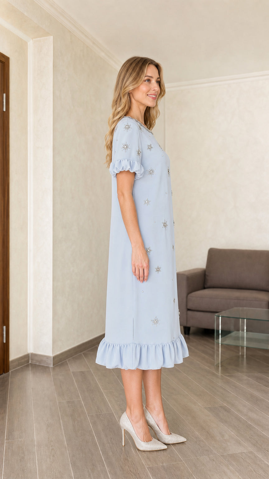 Model wearing light blue embellished midi dress, side view