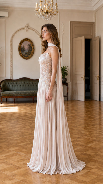 Side profile of elegant champagne maxi evening dress with trailing neck sash