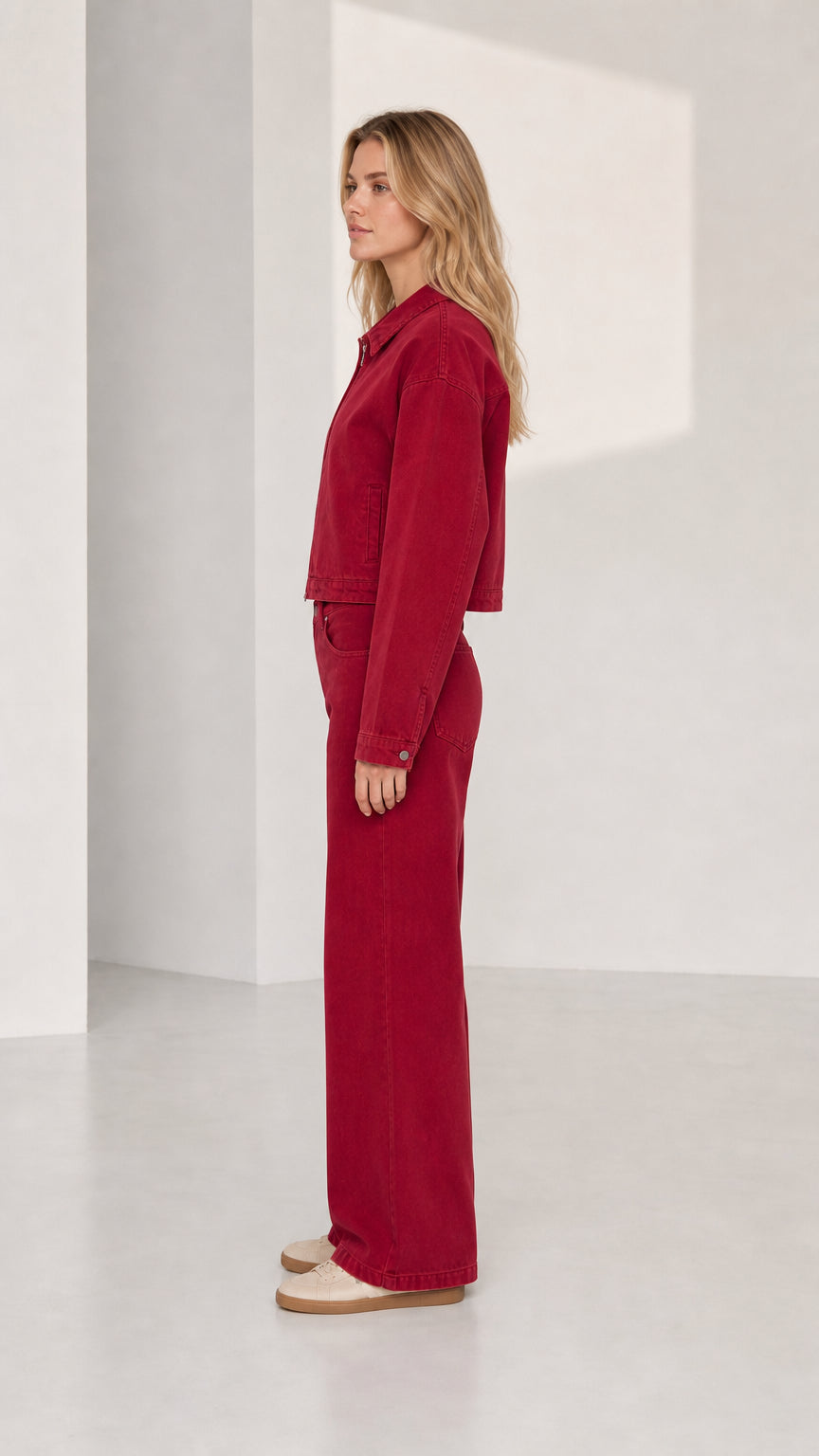 Woman wearing red denim set, side profile view