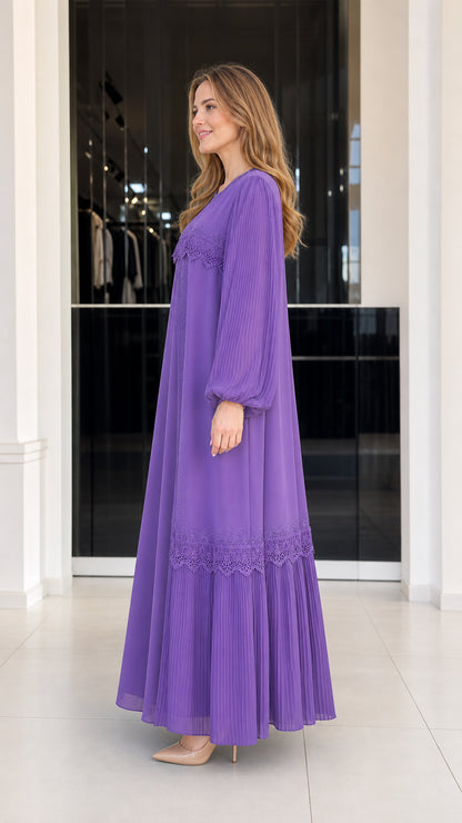 Side profile view of woman wearing purple pleated evening maxi gown