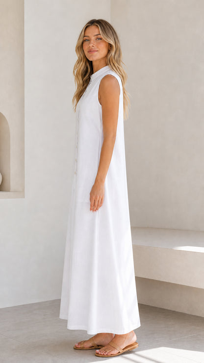 Side profile view of a woman wearing a white sleeveless maxi dress