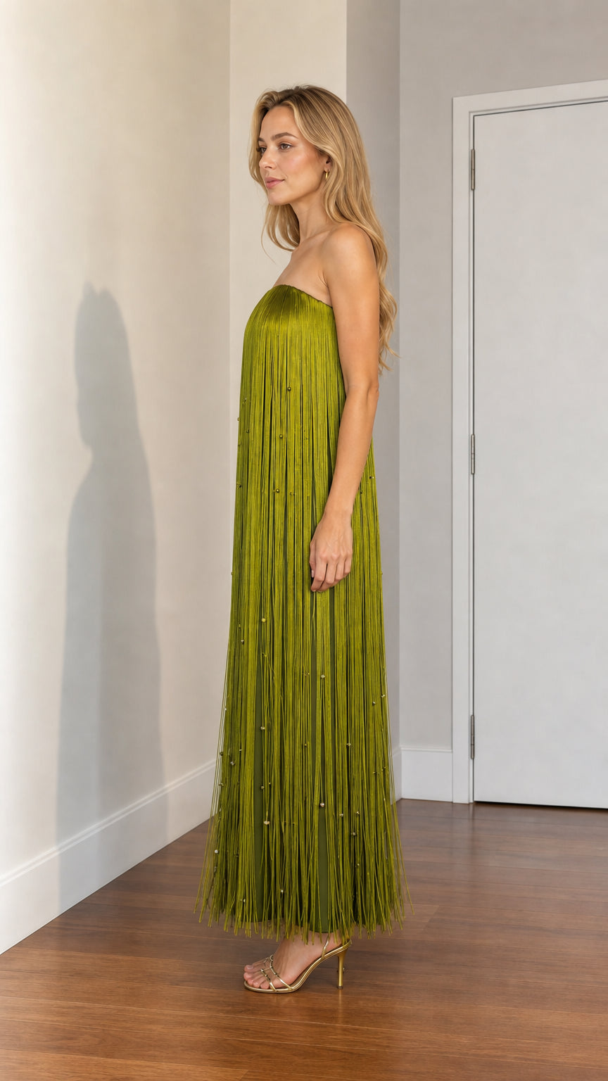 Side profile of woman wearing olive green fringe maxi dress with heels