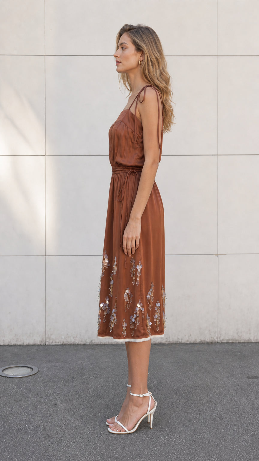 Side view of model wearing brown satin embellished midi slip dress