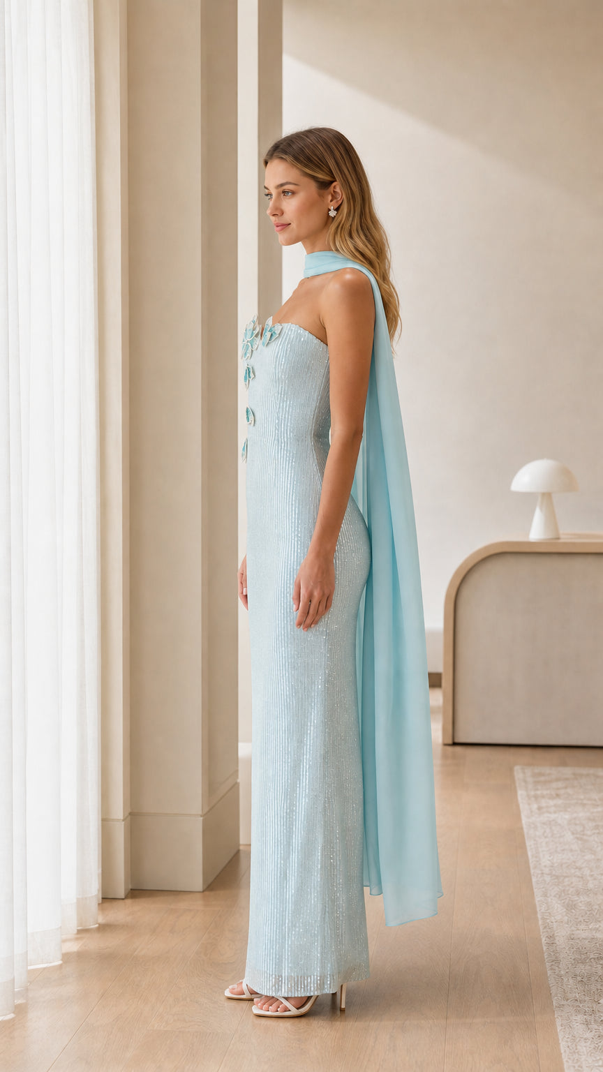 Side profile of light blue strapless evening maxi dress showing slim fit and trailing cape scarf