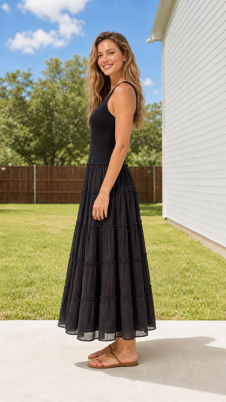 Side 3/4 view of woman wearing Black tiered ribbed tank maxi dress