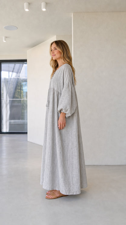 Side angle view of model wearing grey gathered linen-look maxi dress