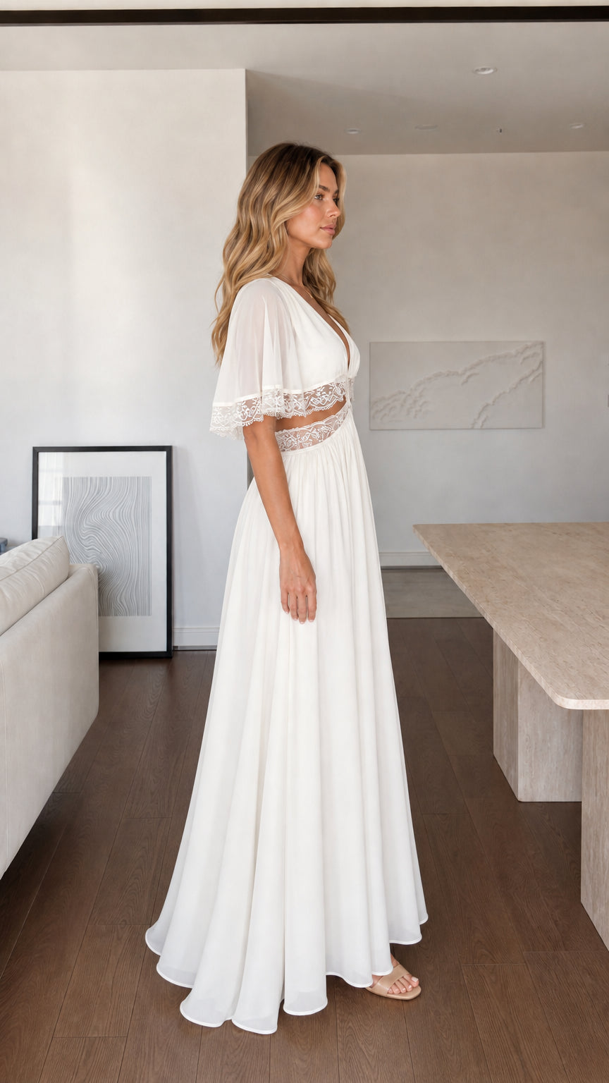 Side profile view of woman in flowing white maxi dress