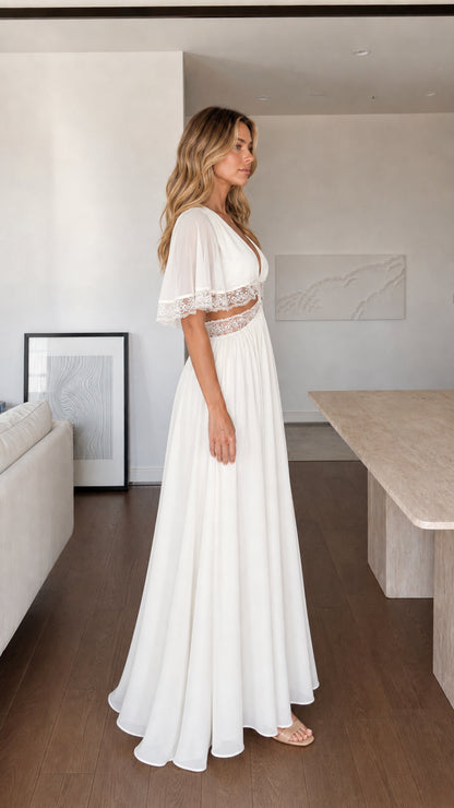 Side profile view of woman in flowing white maxi dress