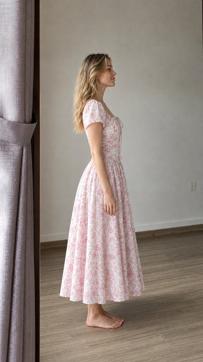 Side profile view of woman wearing pink floral midi dress