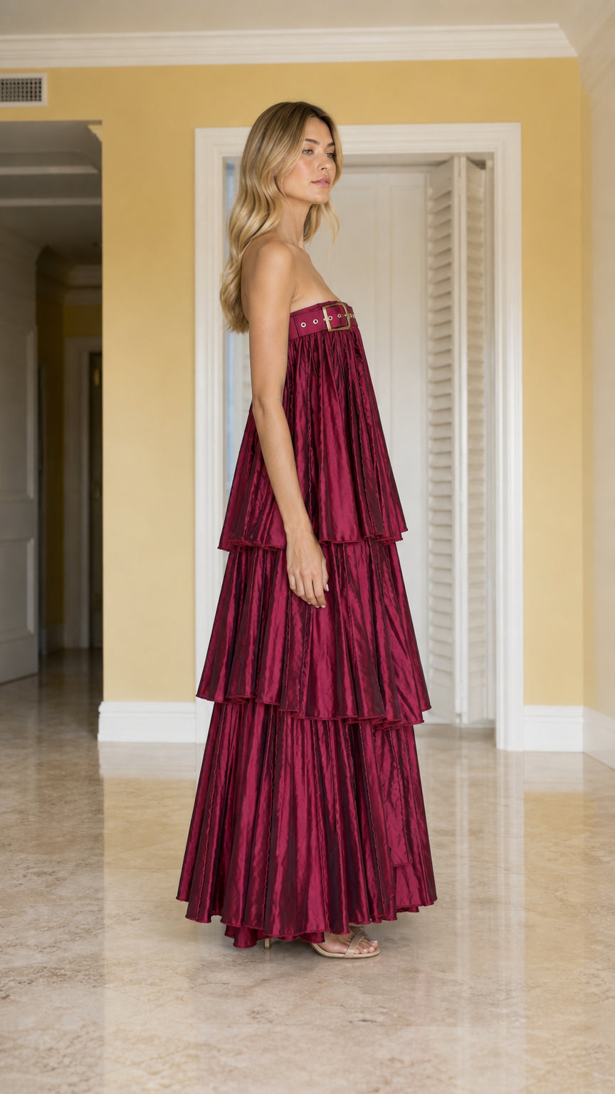 Side angle view of burgundy strapless tiered pleated evening gown
