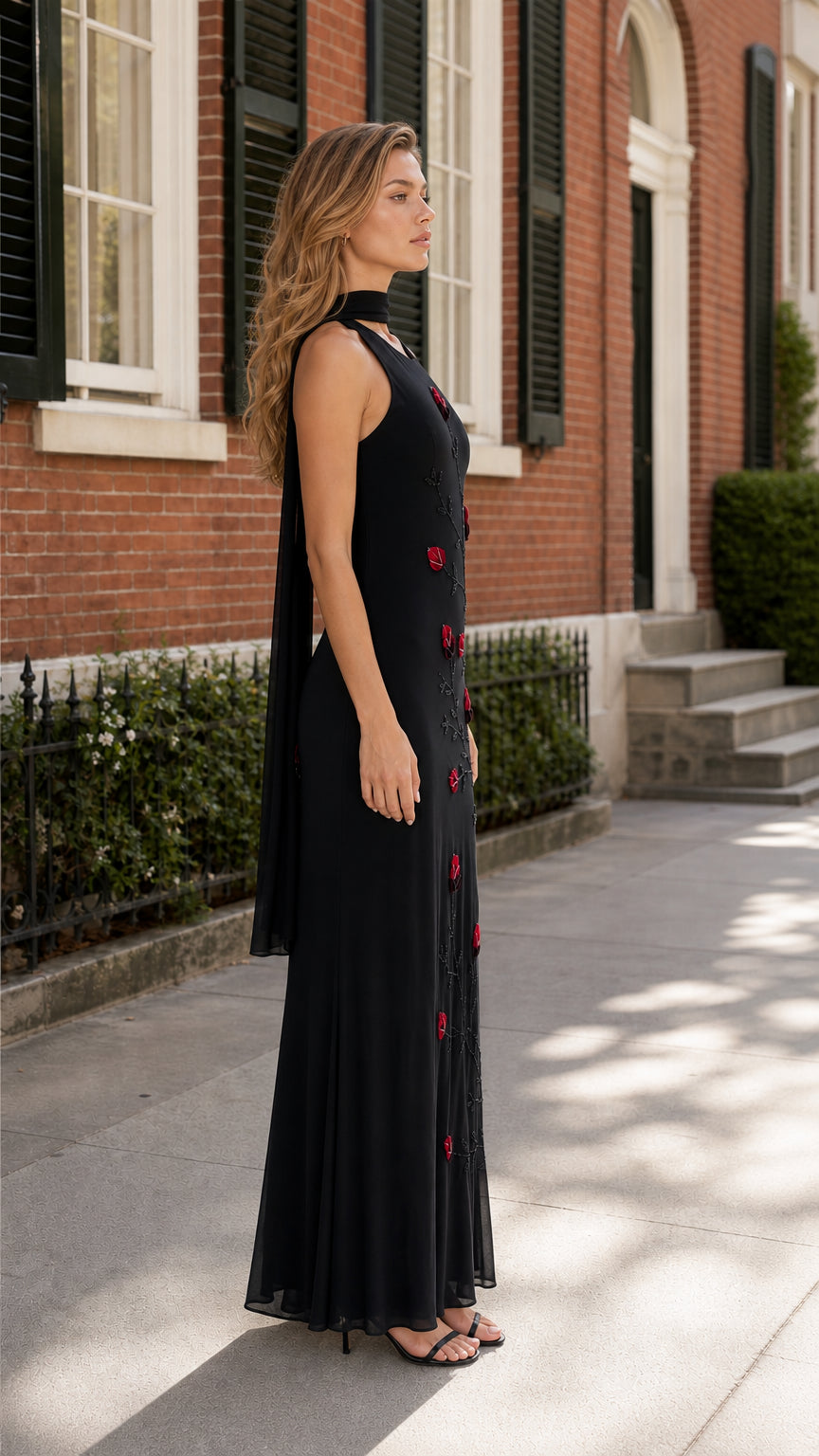 Side profile of black embroidered halter dress with flowing back detail