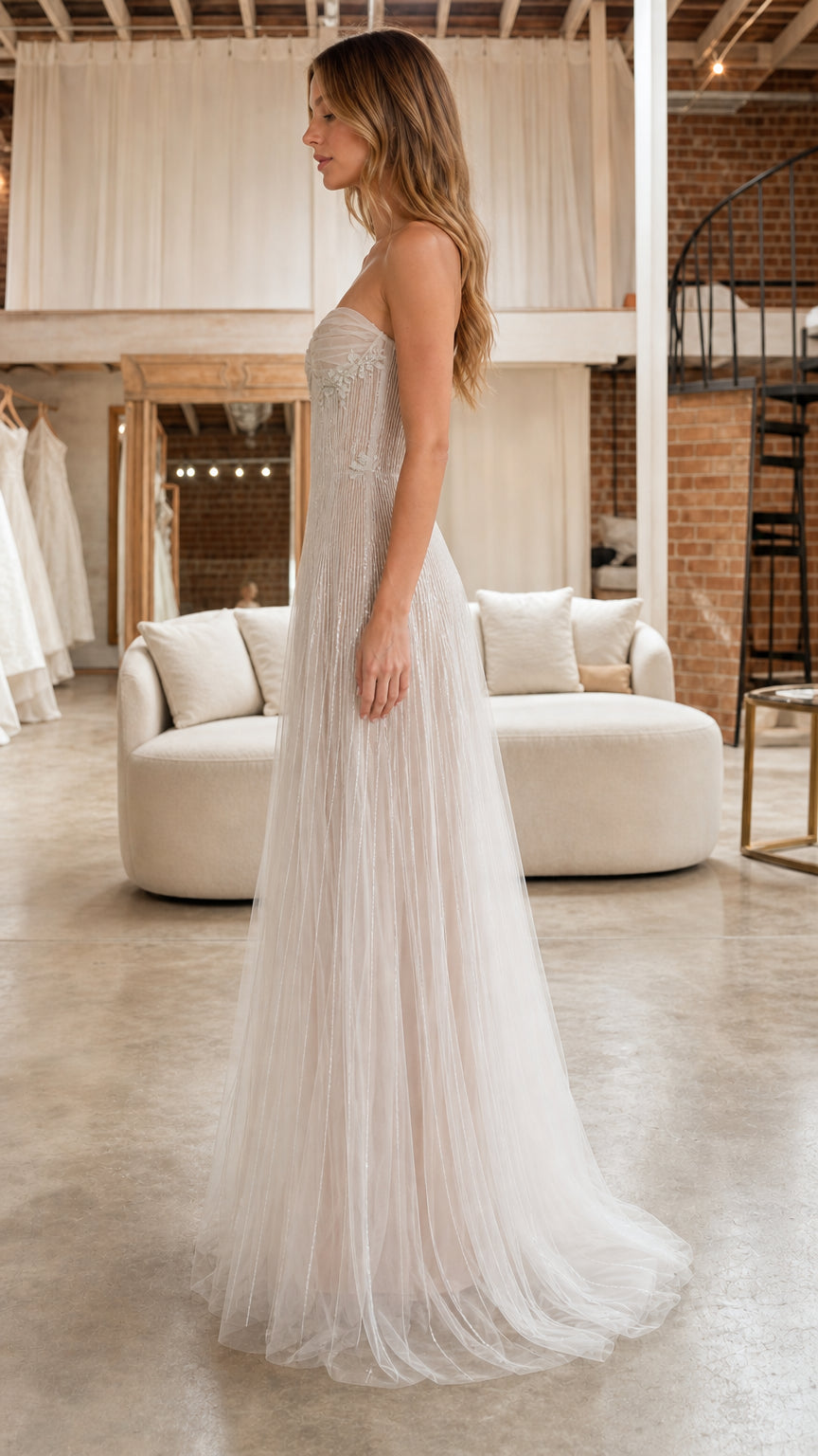 Side profile view of model in the ivory strapless beaded tulle maxi dress