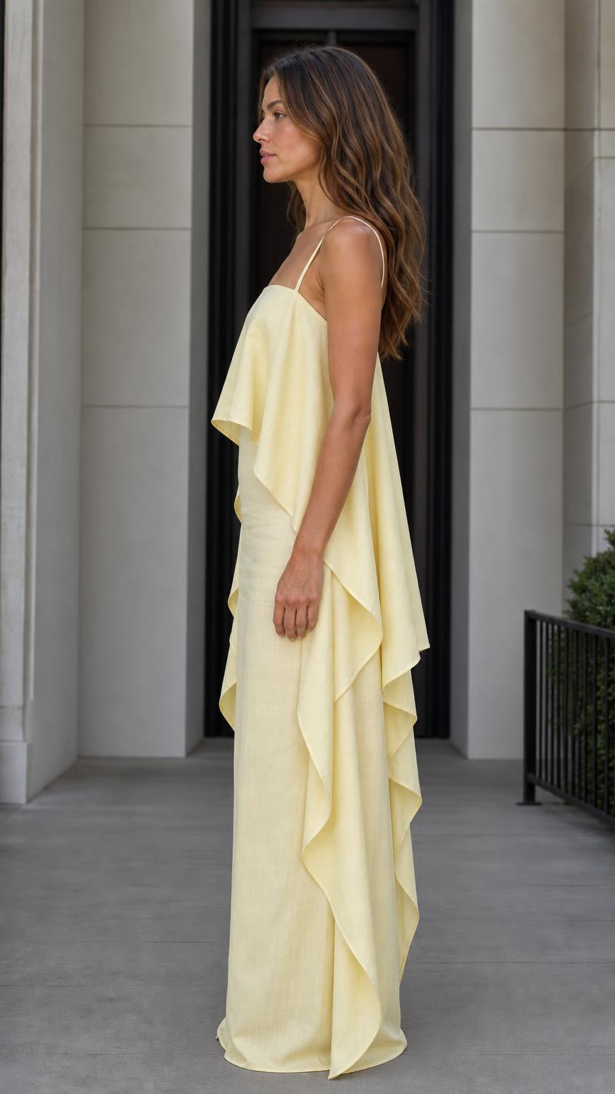 Side profile of model in the yellow maxi dress showing cape detail