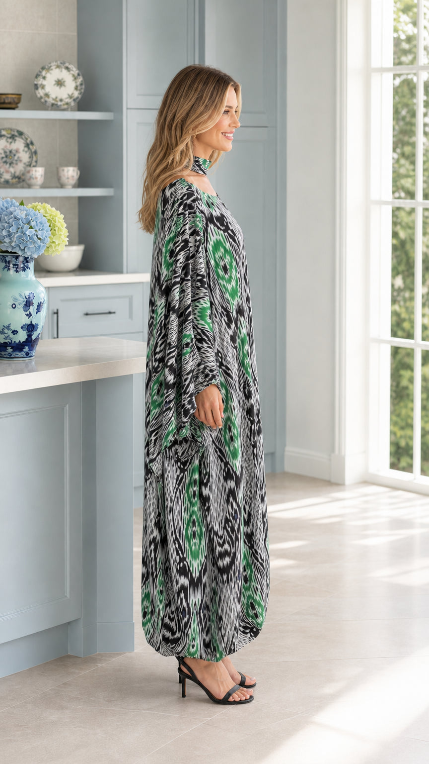 Side profile of woman in flowing emerald green Ikat print kaftan dress
