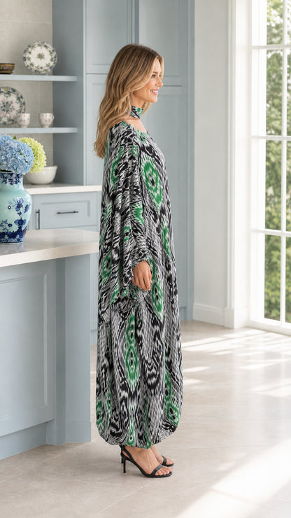 Side profile of woman in flowing emerald green Ikat print kaftan dress