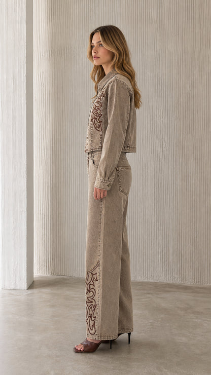 Side profile of model wearing khaki embroidered denim set
