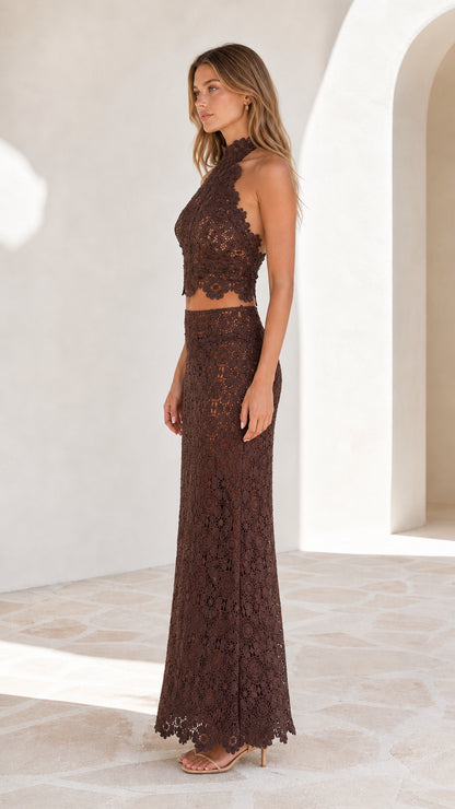 Side profile view of model in brown lace crop top and maxi skirt