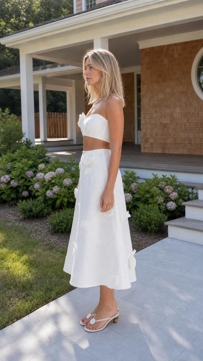 Side profile of woman wearing white strapless crop top and midi skirt