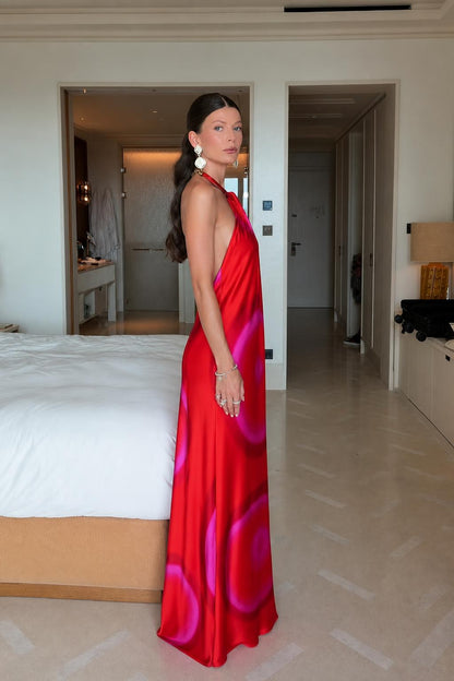 Model wearing red tie-dye satin halter maxi dress side view