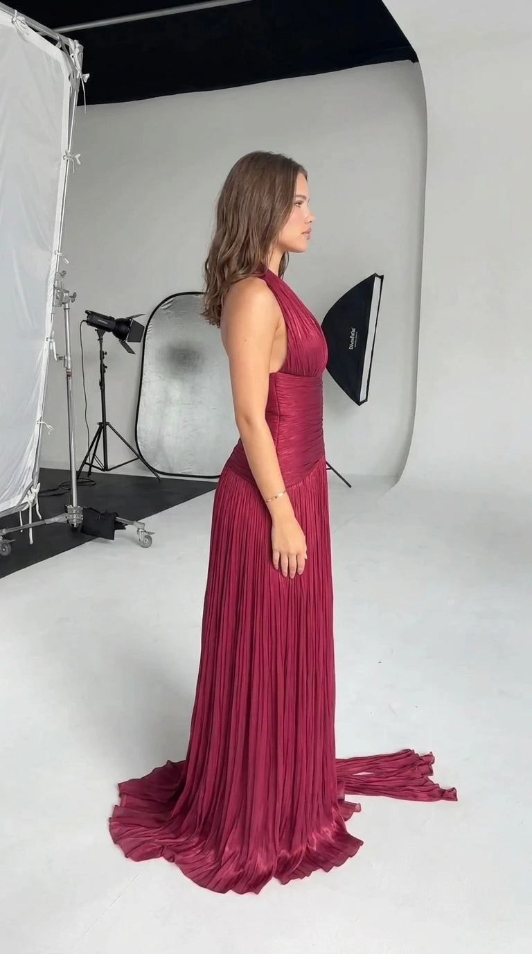 Side profile view of burgundy ruched halter formal dress showing flowing silhouette