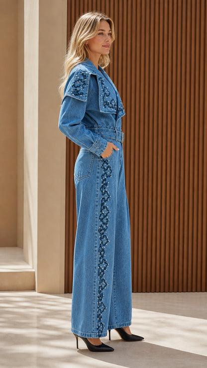 Side profile of model in blue embroidered denim jumpsuit