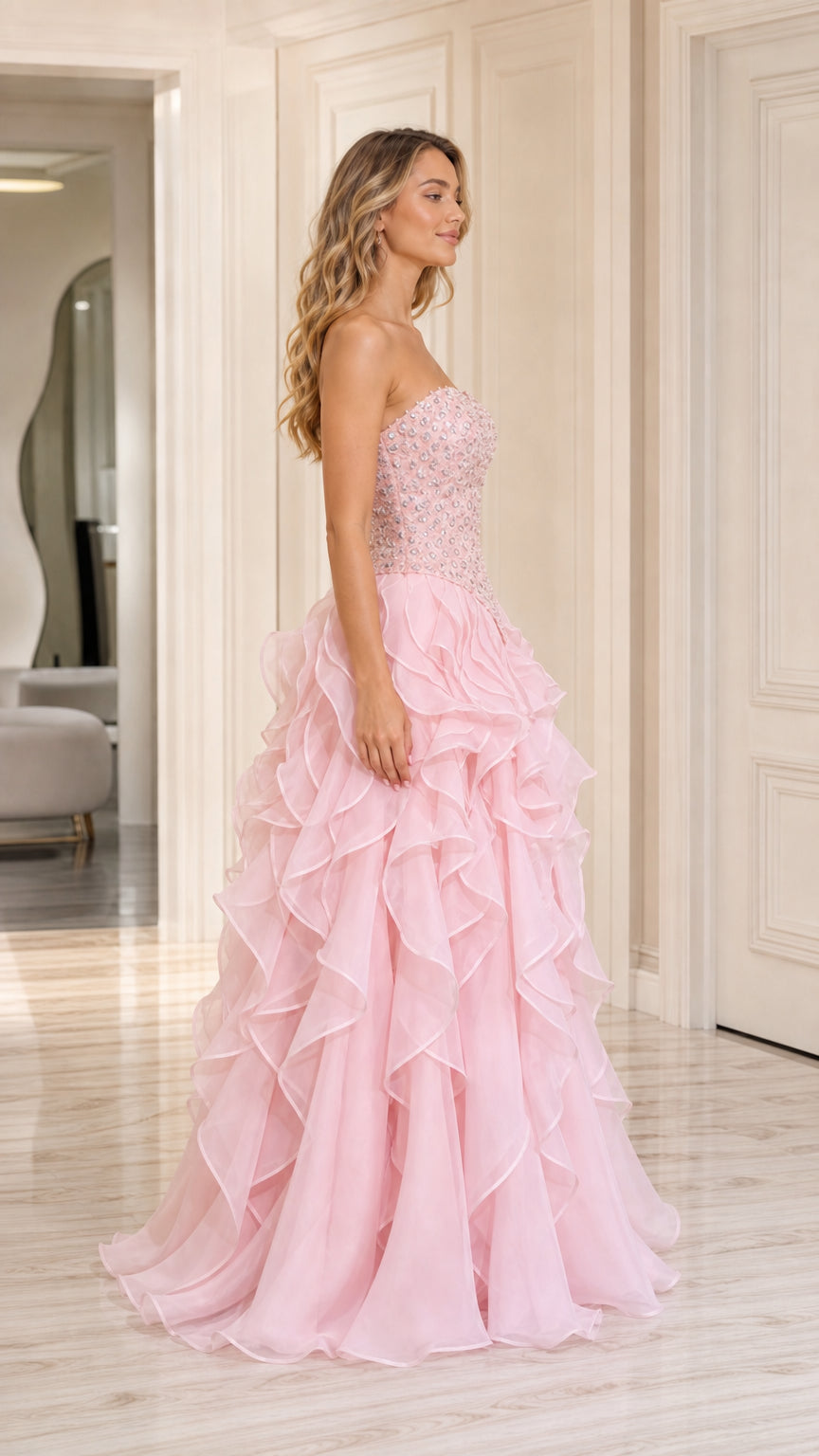 Side angle view of model posing in baby pink beaded formal ball gown