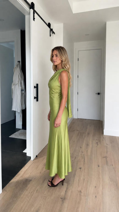 Side view of model in green satin maxi dress