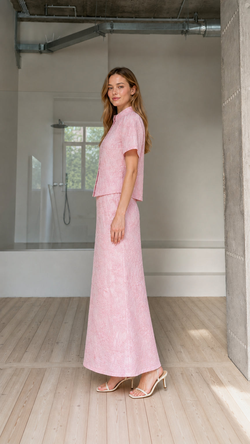 Side view of model wearing pink embroidered two-piece blouse and maxi skirt set