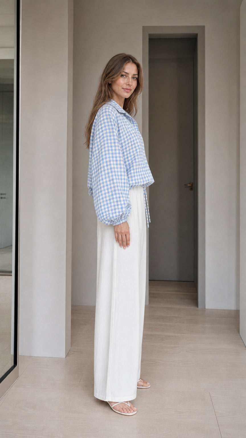 Woman wearing light blue gingham check blouse, side profile view