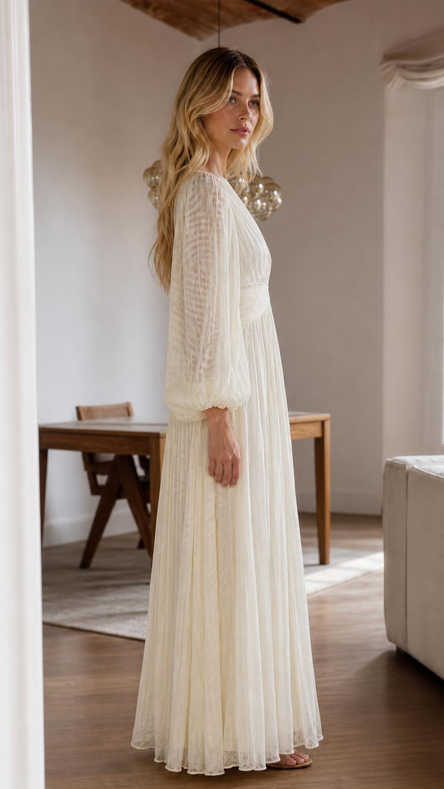 Side profile view of cream pleated maxi dress