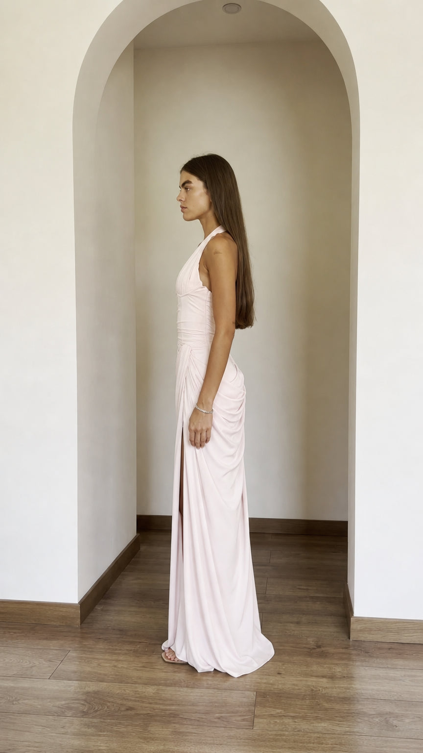 Side profile view of blush pink dress with high slit