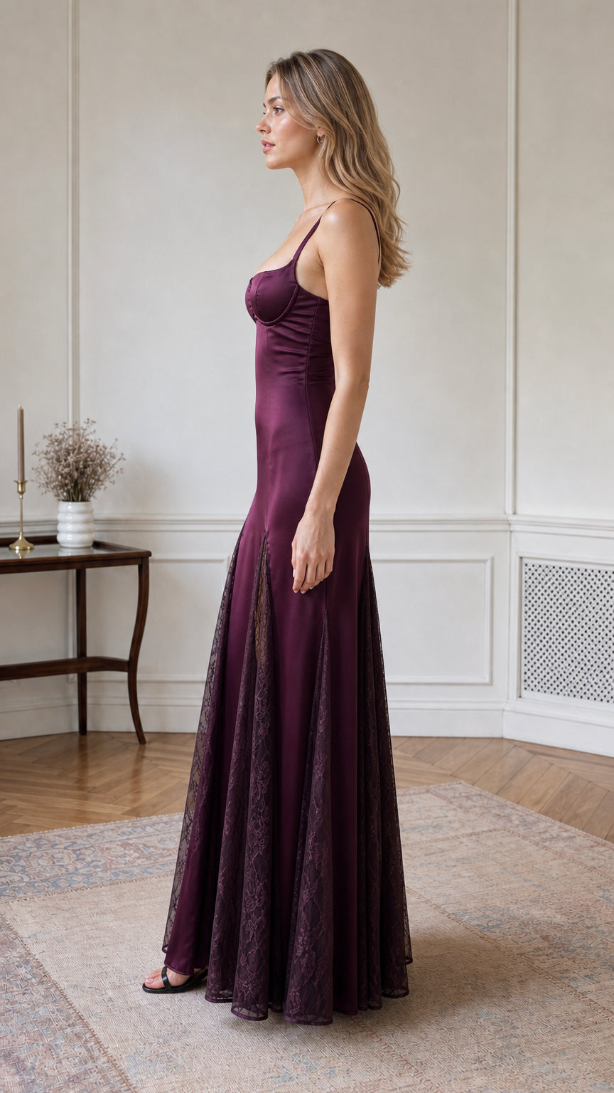 Side profile of model wearing burgundy satin slip gown with flared lace godets