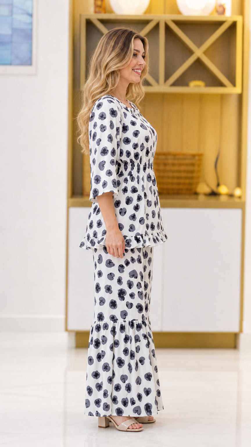 Side view of woman wearing white floral 2-piece set with 3/4 sleeves and flared pants