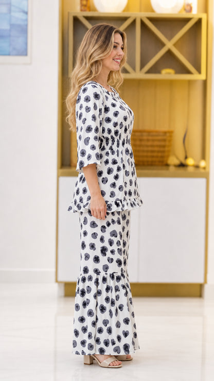 Side view of woman wearing white floral 2-piece set with 3/4 sleeves and flared pants