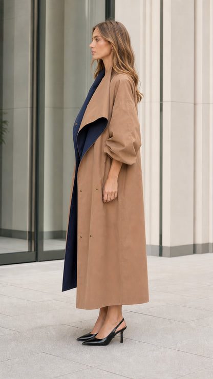 Side profile of woman in camel long duster coat with relaxed balloon sleeves