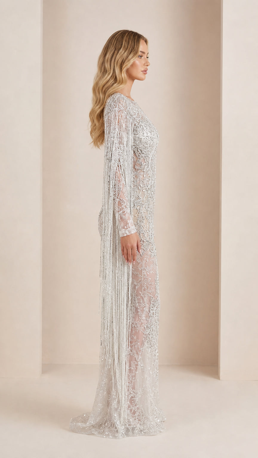 Side profile of model in silver sequin evening gown showing draped sleeve fringe