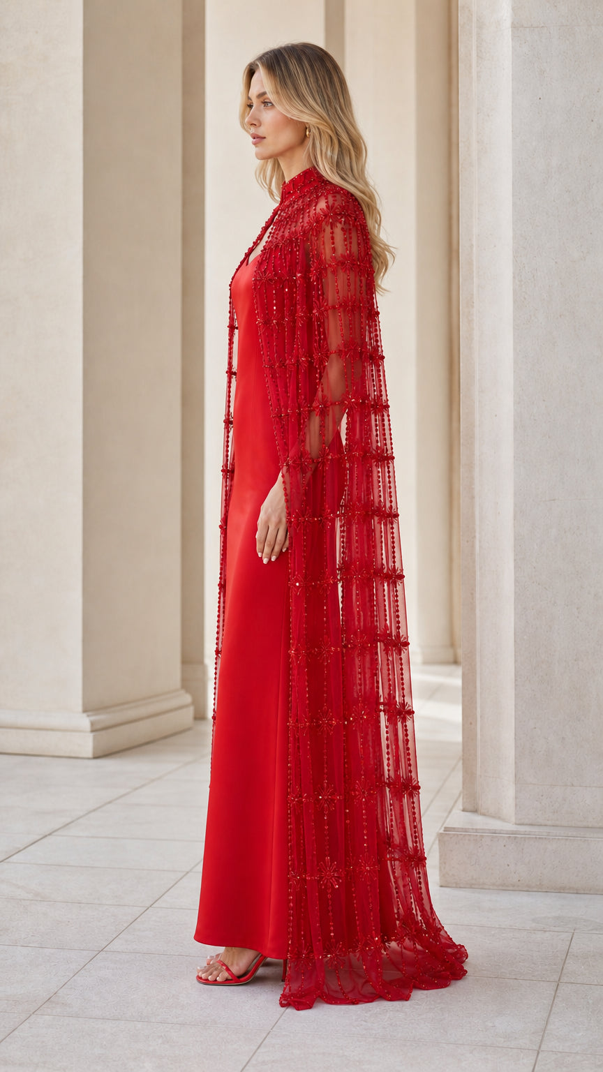 Side profile of model in red evening dress and cape set