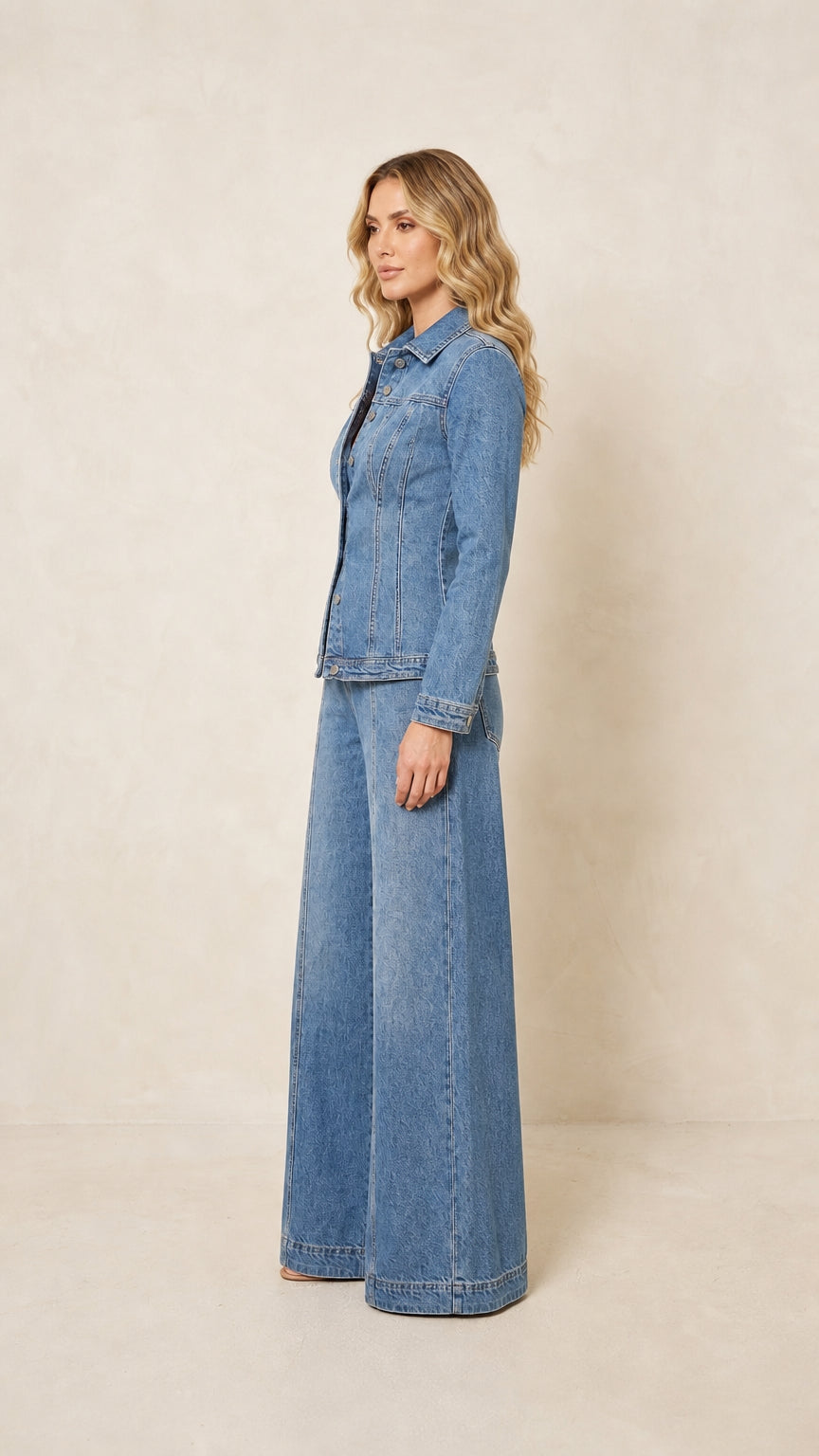 Side view showing the shaped jacket and flowing wide-leg pants in medium wash blue