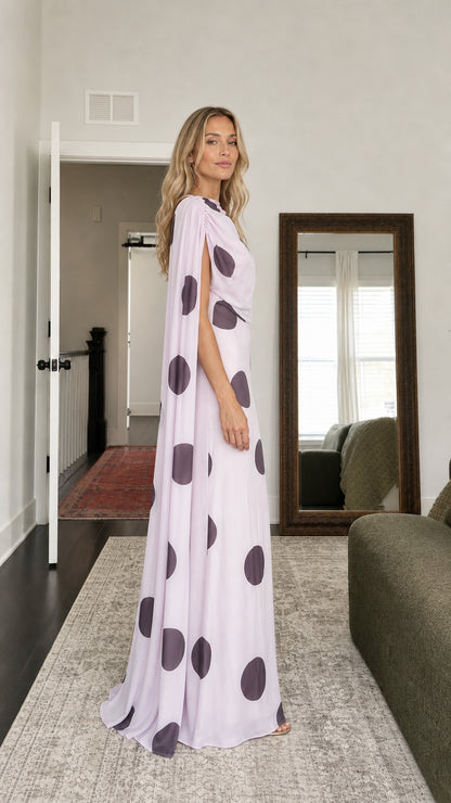 Side profile of model in lavender polka dot cape maxi dress