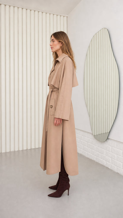 Side profile of model wearing Camel longline trench coat showing drape and side slit