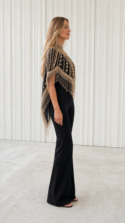 Side profile of model showing draped beaded fringe capelet in black and gold