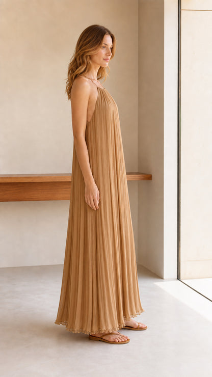 Model wearing camel pleated halter maxi dress, side profile