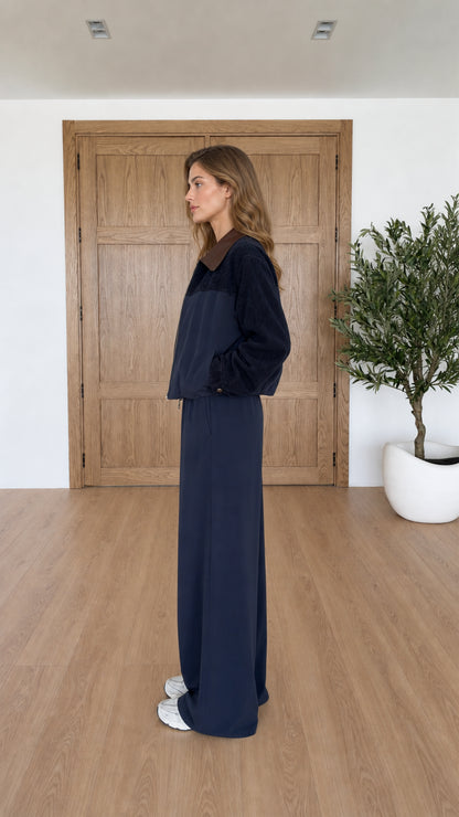 Side profile of navy blue zip jacket and wide leg pants set