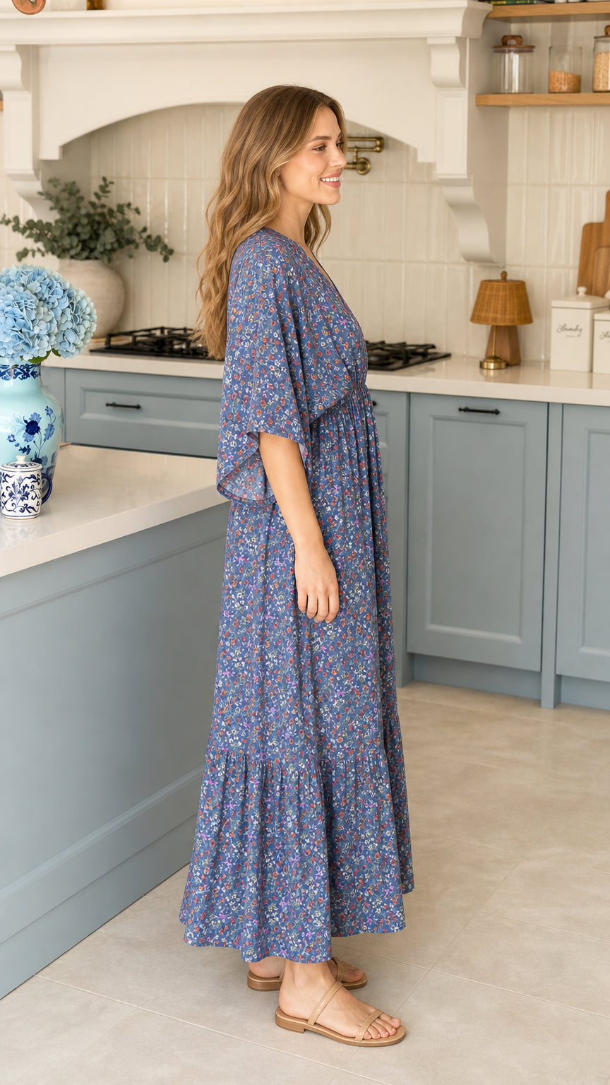 Side profile view of blue ditsy floral tiered maxi dress