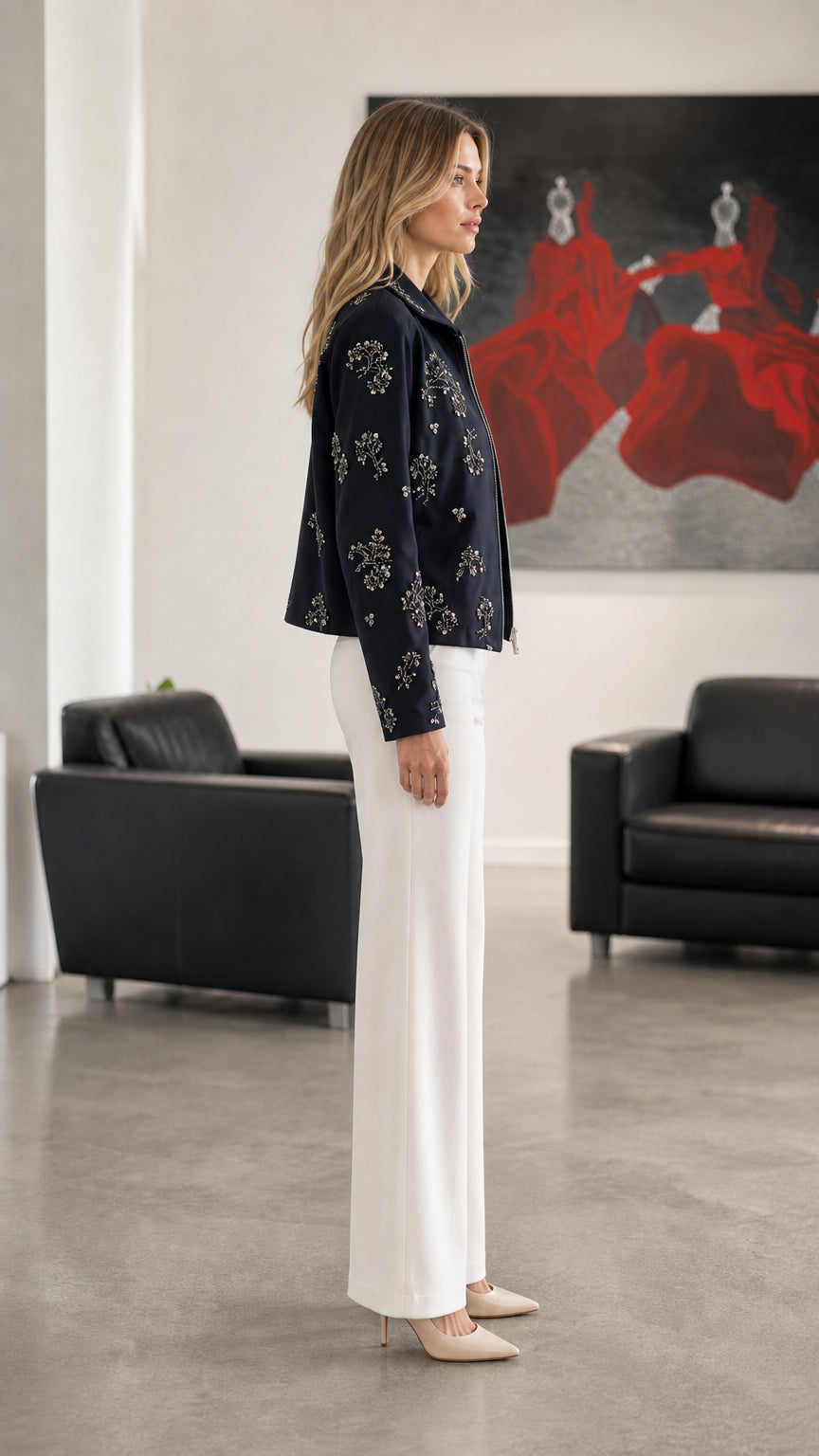 Woman wearing Navy embellished floral zip-up jacket, side profile view