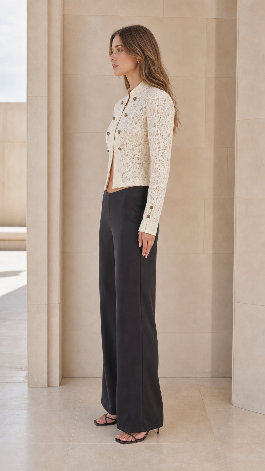 Side profile of woman in ivory lace jacket