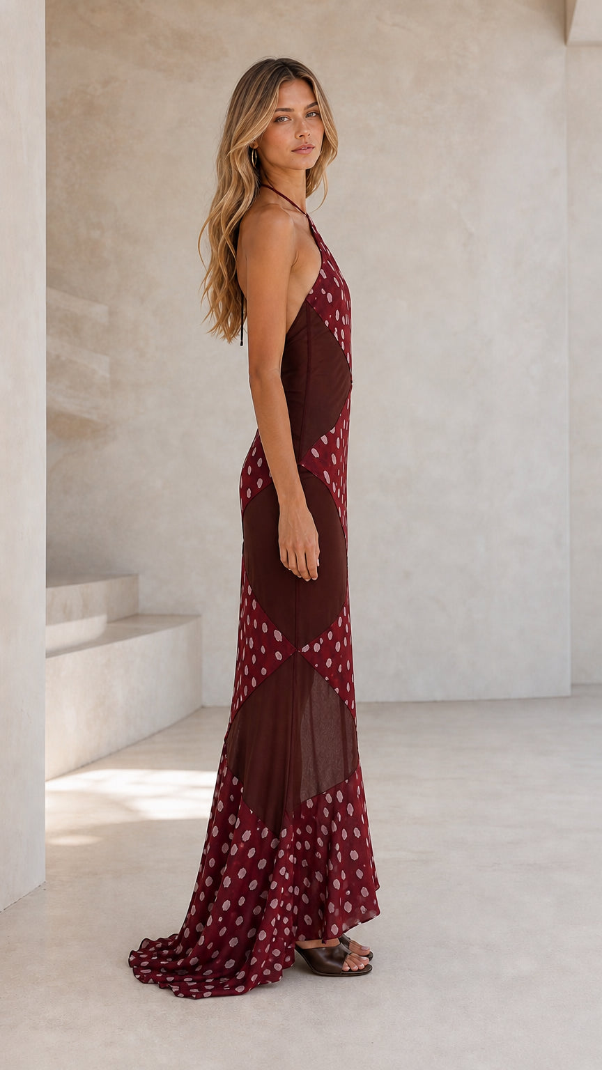 Side profile of model wearing burgundy maxi dress