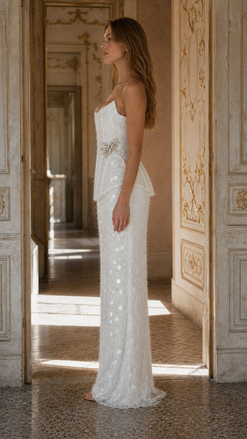 Side profile view of white sequin corset maxi gown showing peplum and floor-length skirt